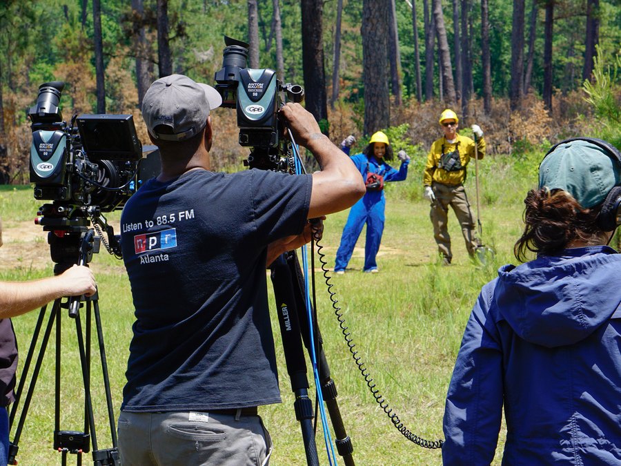 A Georgia Public Broadcasting camera crew filming Chelsea on location in a forest