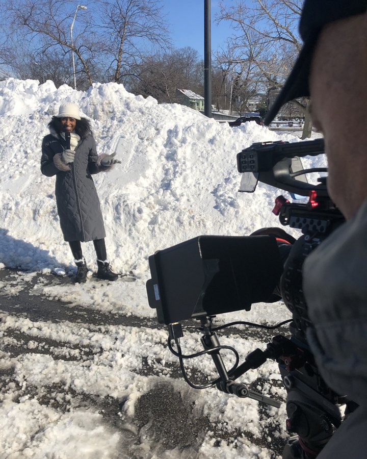 Chelsea reporting in the snow while a camera operator rolls