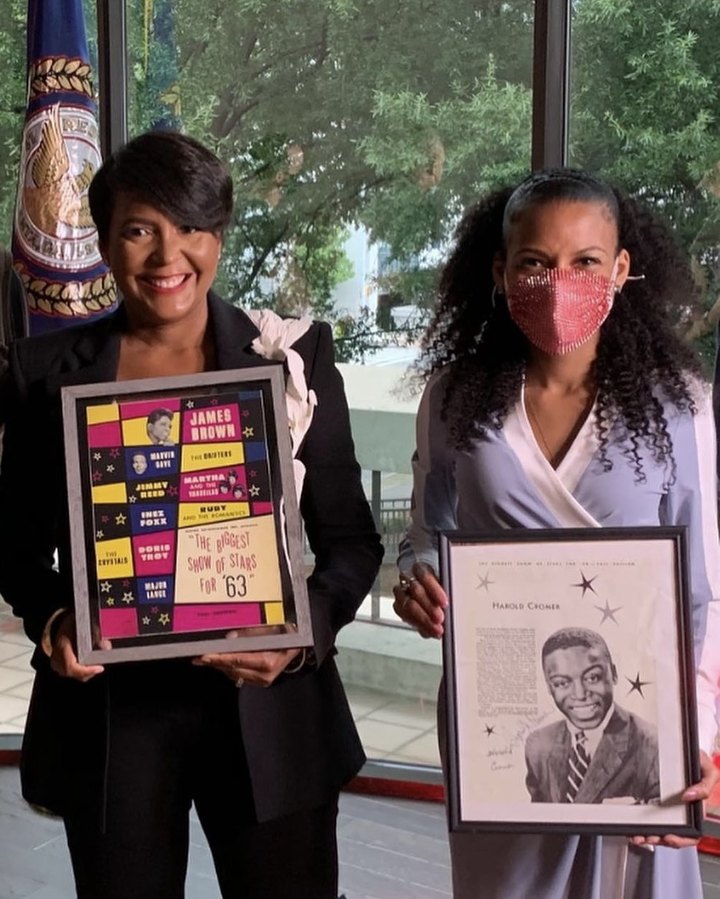 Chelsea and Mayor Keisha Lance Bottoms holding framed vintage show posters